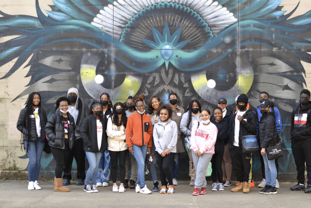 Group of students in front of a mural
