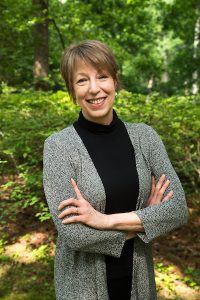 Photo of Elizabeth Warren, woman with arms crossed, smiling at camera